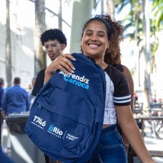 Imagem de garota participante do programa Aprendiz Carioca com mochila azul na mão