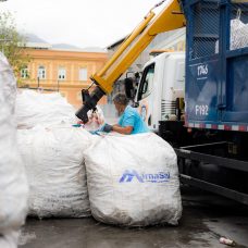 Mulher faz divisão de resíduos em cooperativa de coleta seletiva